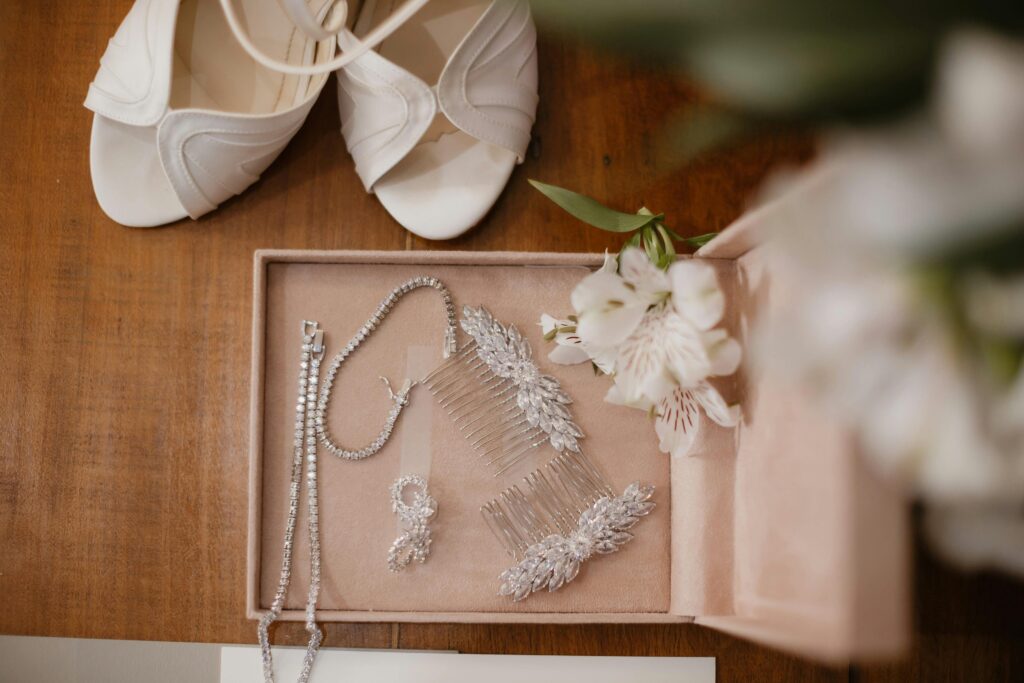 A flat lay of elegant bridal jewelry and white heels, perfect for a wedding day.