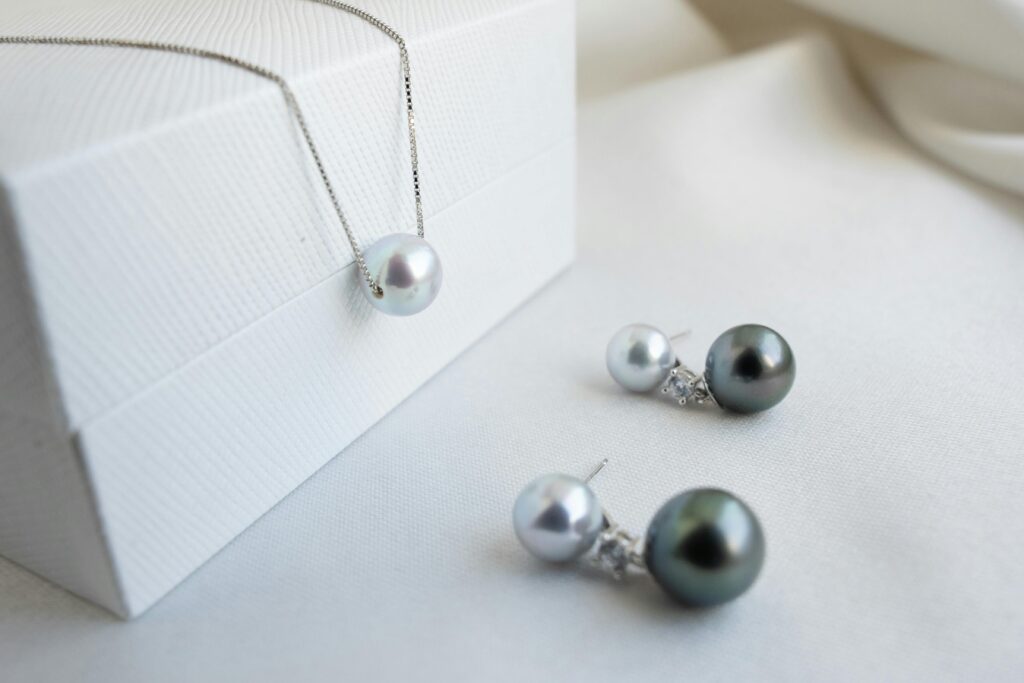 Exquisite pearl necklace and earrings set with a modern design on a crisp white backdrop.