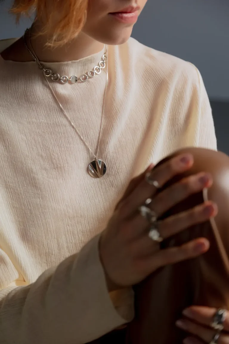 Close-up of an elegant woman wearing silver jewelry with a stylish outfit.